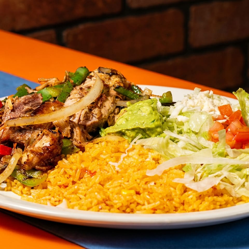 A vibrant Mexican dish with fajitas, rice, guacamole, lettuce, tomatoes, and cheese.